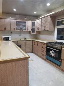 Ithnaynفلل فندقية بمدينة تنومة的厨房配有木制橱柜和炉灶。