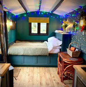 HunworthOld King William Shepherd Huts and Private Hot Tubs in North Norfolk的一间设有床铺的卧室,位于蓝色灯光的房间