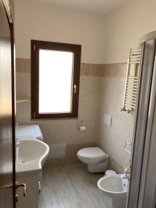 奥尔比亚Smeralda的一间带水槽和卫生间的浴室以及窗户。