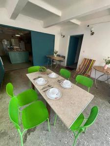 乌雷基Qiwi House的配有桌子和绿色椅子的房间