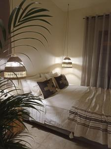 菲尼卡斯Petra Lodge的一间卧室配有一张白色床和两盏吊灯