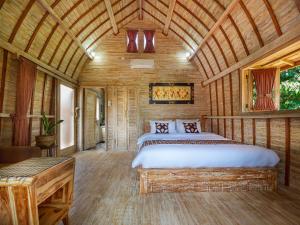 乌鲁瓦图Wisnu Lumbung Uluwatu的木制客房内的一间卧室,配有一张床