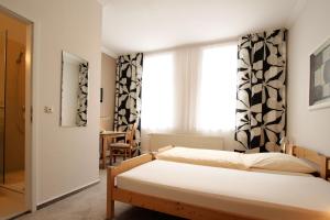 希尔泽Hotel Galerie的一间卧室设有两张床和窗户。