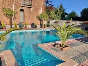 科布列季David's Guest House的一座砖砌建筑旁的棕榈树游泳池