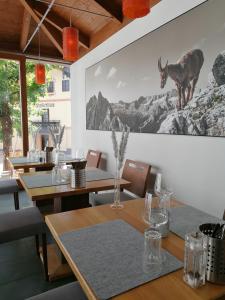 纽科琴格罗斯夫霍夫豪斯旅馆的一间设有桌子的用餐室,墙上挂着一幅鹿的照片