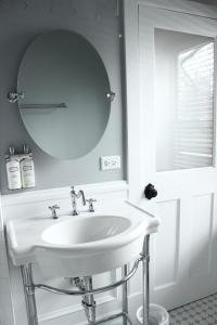 PlainfieldThe Plainfield Inn的浴室设有白色水槽和镜子