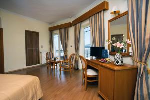 米蒂利尼蓝色海洋酒店的酒店客房设有书桌和卧室。