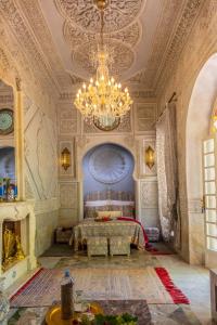 杰迪代Riad Dar El Malaika的大型客房配有一张床和吊灯。