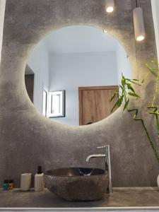 佩里萨Villa Konstantinos的一间带石制水槽和镜子的浴室