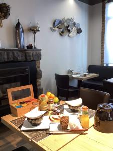 ChoozAUBERGE DE LA VOUTE的餐桌、食物和壁炉
