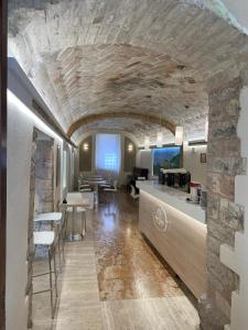 阿西西Camere Santa Chiara的一间厨房和带石墙的用餐室