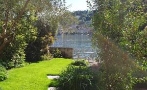 奥尔塔圣朱利奥La Casa dell'Isola的从树木繁茂的庭院欣赏湖景