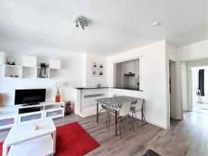 尼乌波特Appartement 2 chambres 200m plage Nieuwpoort Bad的白色的客厅配有桌椅