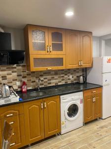 乌宗Sarahome Apart的厨房配有木制橱柜和洗衣机。