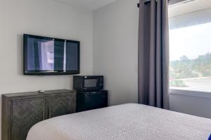 大洋城The ShoreHouse的卧室配有一张床,墙上配有电视。