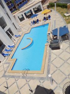 沙姆沙伊赫Jewel Sharm El Sheikh Hotel的享有带椅子和遮阳伞的游泳池的上方景色