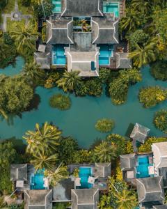 迈考海滩Anantara Mai Khao Phuket Villas的享有河流的空中景致,拥有房屋和树木