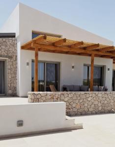 拉卡尼亚Alykes Beachside Stylish Villas with Private Pool South Rhodes的白色的房子,设有石墙和木制凉亭