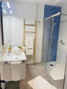 阿罗纳Torres Beach的一间带玻璃淋浴和水槽的浴室
