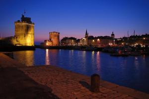 拉罗谢尔NUIT SUR UN BATEAU VIEUX PORT的夜水里有城堡的城市