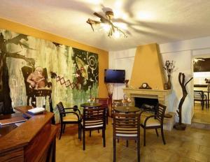 米利纳Ikosimo Guesthouse的一间带桌椅和壁炉的用餐室
