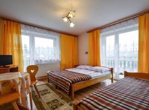 克罗奇琴科Pokoje gościnne u Bożenki的一间卧室设有两张床和两个窗户。