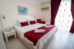 帕莫卡莱阿亚帕姆酒店的一间卧室配有一张大床和红色枕头