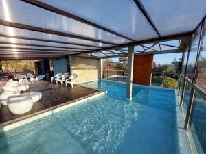 维拉卡洛斯帕兹Costalago Suites- By HVH的一座带椅子的大型游泳池和一座建筑