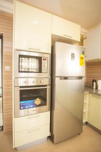 阿克拉Accra Luxury Homes @ East Legon的厨房配有不锈钢冰箱和烤箱