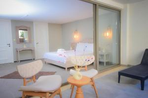 阿拉恰特9 Alacati Boutique Hotel的卧室配有一张床和一张桌子及椅子