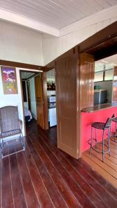 巴雷里尼亚斯Condomínio Eco Resort Lençóis的铺有木地板,设有带酒吧和椅子的厨房