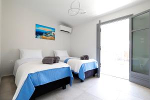 爱琴娜岛AXS Top Floor Apartment的一间卧室设有两张床和滑动玻璃门