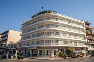 米蒂利尼蓝色海洋酒店的一座白色的大建筑,上面有蓝色的海标