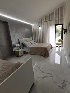 赫拉克勒亚米诺亚La valle degli dei的一间设有两张床的卧室,铺有大理石地板。
