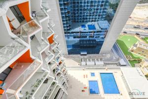 迪拜Urban 1BR at Binghatti Stars Dubai Silicon Oasis by Deluxe Holiday Homes的享有带游泳池的建筑的空中景致