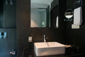 甘托克Ramada by Wyndham Gangtok Hotel & Casino Golden的浴室设有白色水槽和镜子