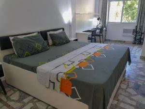 RomblonThe Three P Beach Resort & Dive Center的一间卧室配有两张带绿色和橙色床单的床