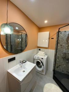 德鲁斯基宁凯Alėjos Apartmentai City的一间带水槽和洗衣机的浴室