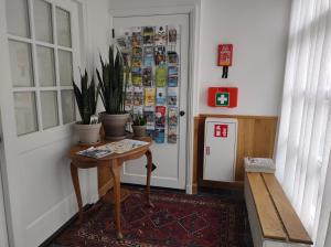 米德尔堡VRYE HEERLYKHEYD ( adults only ) studio 2的门旁的走廊上设有桌子和盆栽植物