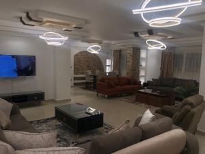 开罗Ghena的带沙发和平面电视的客厅