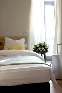 埃朗根斯塔德豪斯酒店的卧室配有白色的床和窗户。