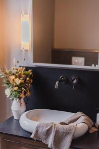 埃朗根斯塔德豪斯酒店的浴室设有水槽和花瓶