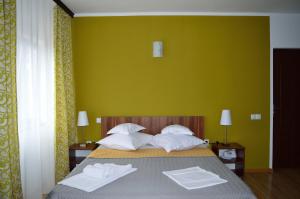 旧瓦马Helen Vama Veche的一间卧室配有一张带两条白色毛巾的床