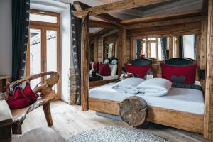 普夫龙滕Boutiquehotel Blaue Burg Falkenstein的一间卧室配有两张木制床和红色枕头