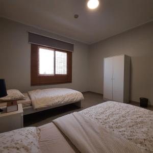 阿卜杜勒国王经济城سن رايز的一间卧室设有两张床和窗户。