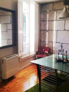 维戈Acogedor apartamento en el Casco Antiguo的配有桌椅和砖墙的房间