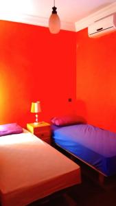 奥比丹The Guest House Bin Elouidane的红色墙壁客房的两张床