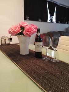 瓦尔纳Вила Полина的一张桌子,上面放着一瓶葡萄酒和一瓶粉红色玫瑰花