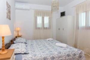 纳克索乔拉Villa Galante, (croft house nearby the sea)的一间卧室配有一张床和一张带台灯的桌子