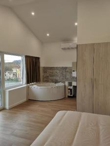卡马乔Villas Camargo.suites的卧室设有大浴缸和大窗户